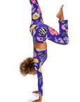 Person wearing colorful leggings with a zebra pattern, performing a handstand on a white background