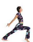 Person wearing a colorful outfit with abstract patterns, posing on a white background